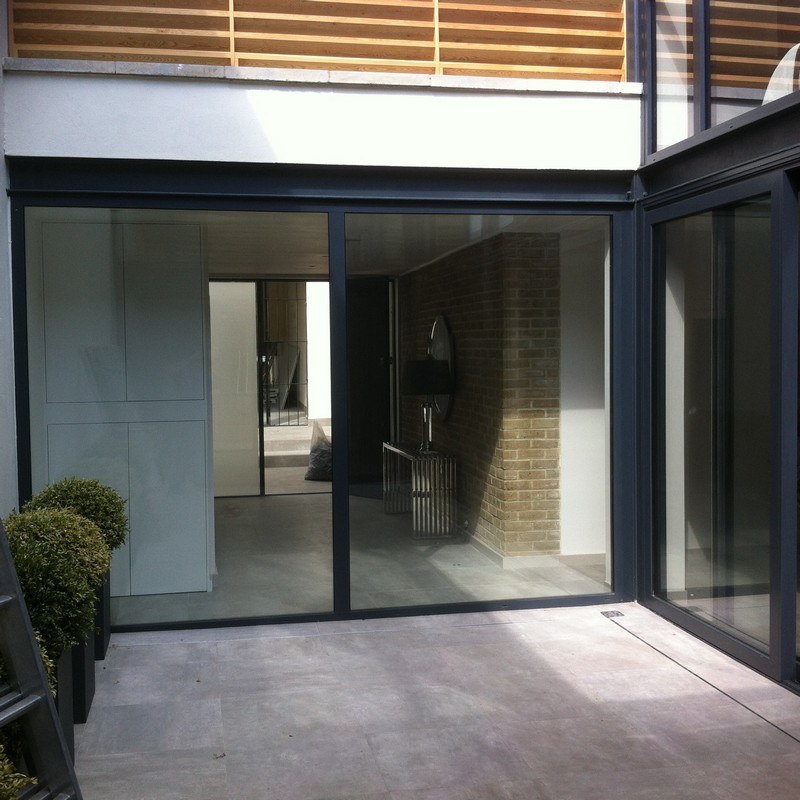 Floor-to-ceiling sliding doors opening to courtyard in Feltham