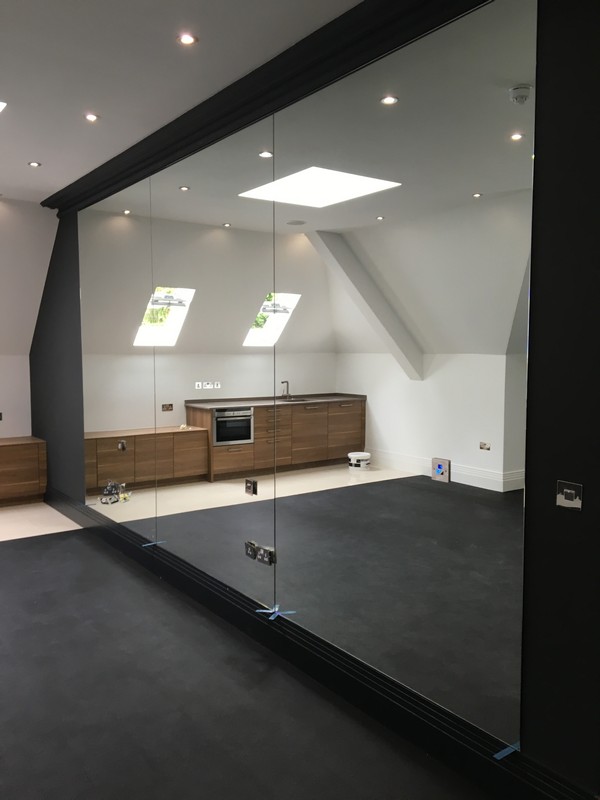 Frameless glass partition in loft conversion by Feltham glaziers
