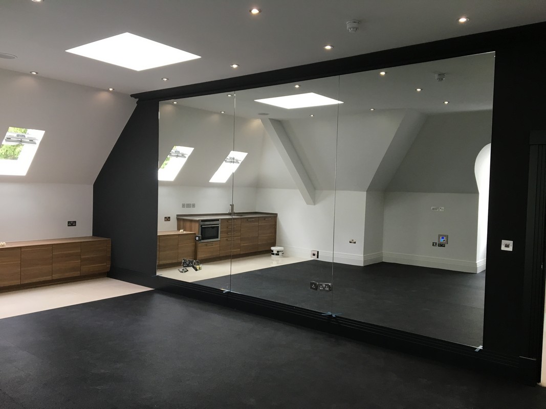 Frameless glass wall dividing loft conversion in Feltham